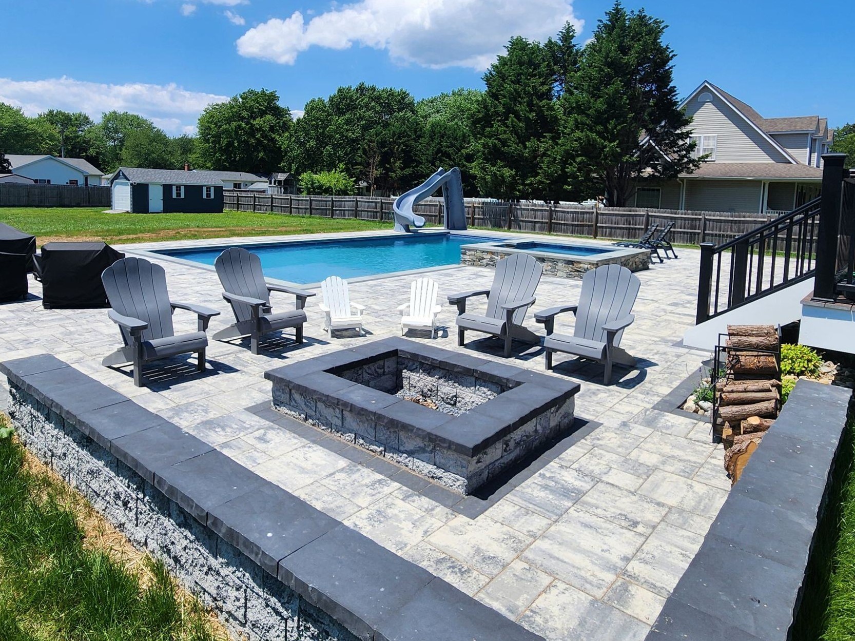 geometric pool and spa with slide and fire pit