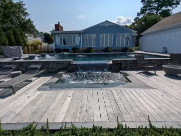 A custom pool with a waterfall by Coastal Pools in Maryland