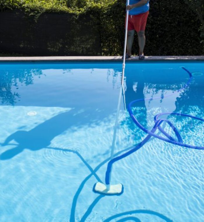 A person cleaning a pool